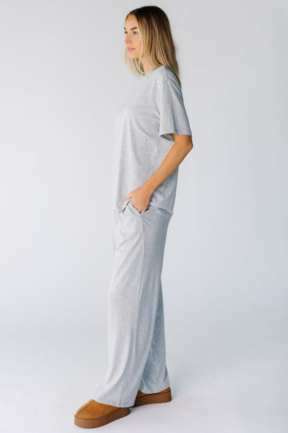 Side view of a woman wearing a heather grey lounge set with short sleeves and wide cut lounge pants with pockets