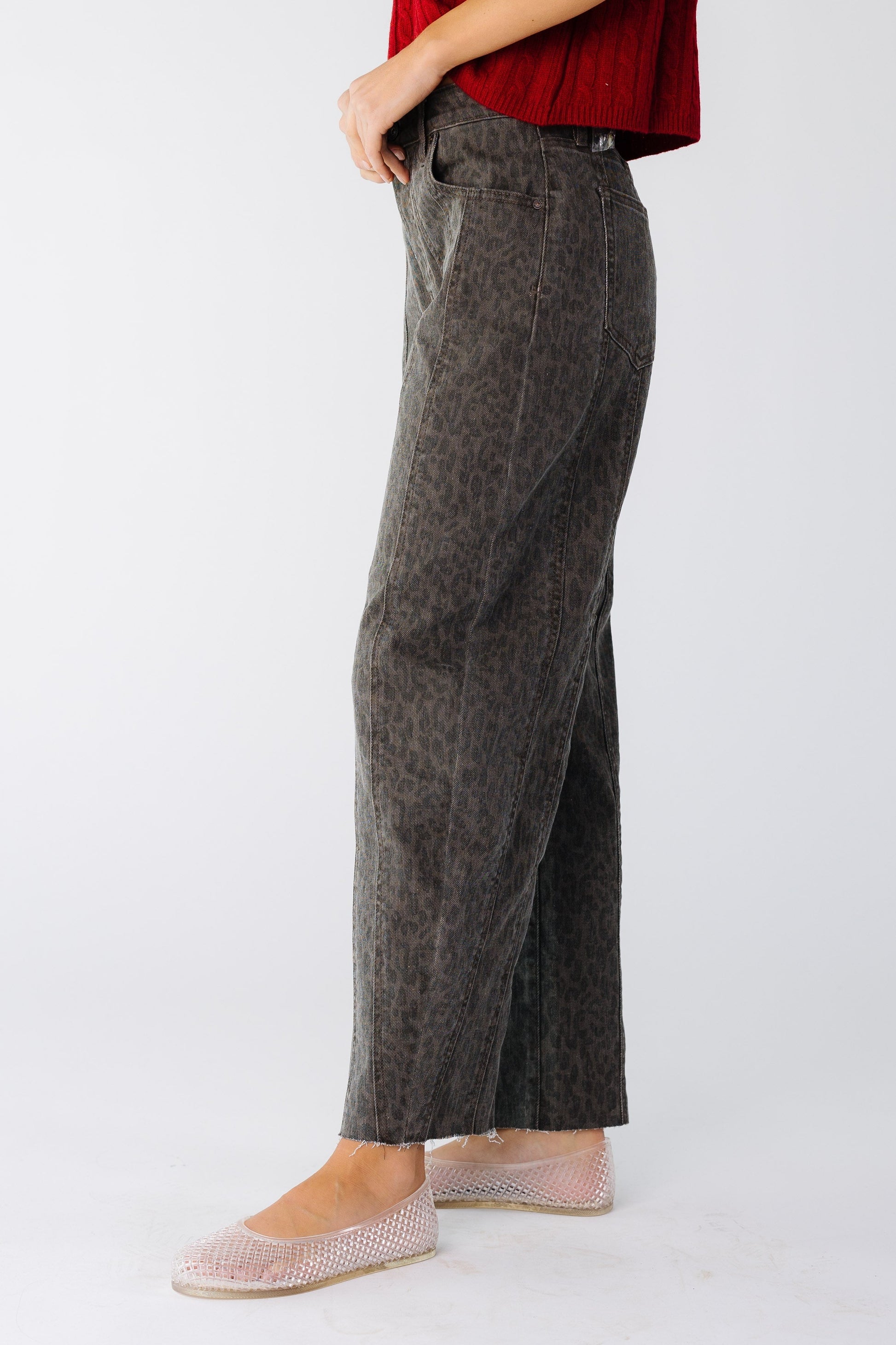 Side view of a woman wearing a pair of loose fitting barrel jeans in a brown cheetah print