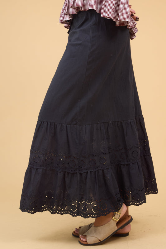 Young woman wearing a modest black midi skirt with a wide eyelet ruffle.