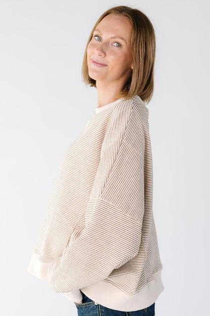 Side view women wearing a camel stripe sweatshirt with drop shoulders