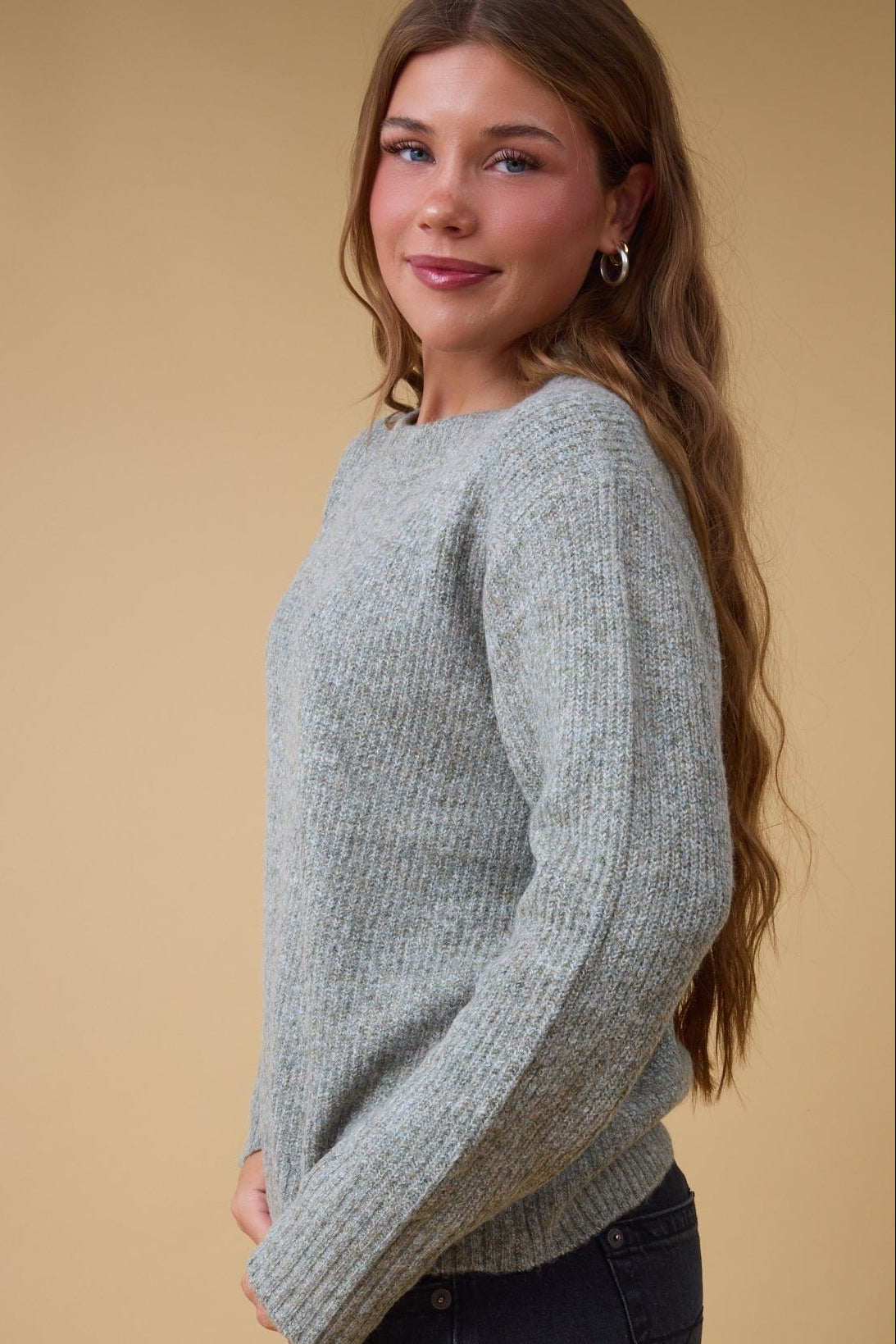 Young woman wearing a modest rib knit sweater with long sleeves.