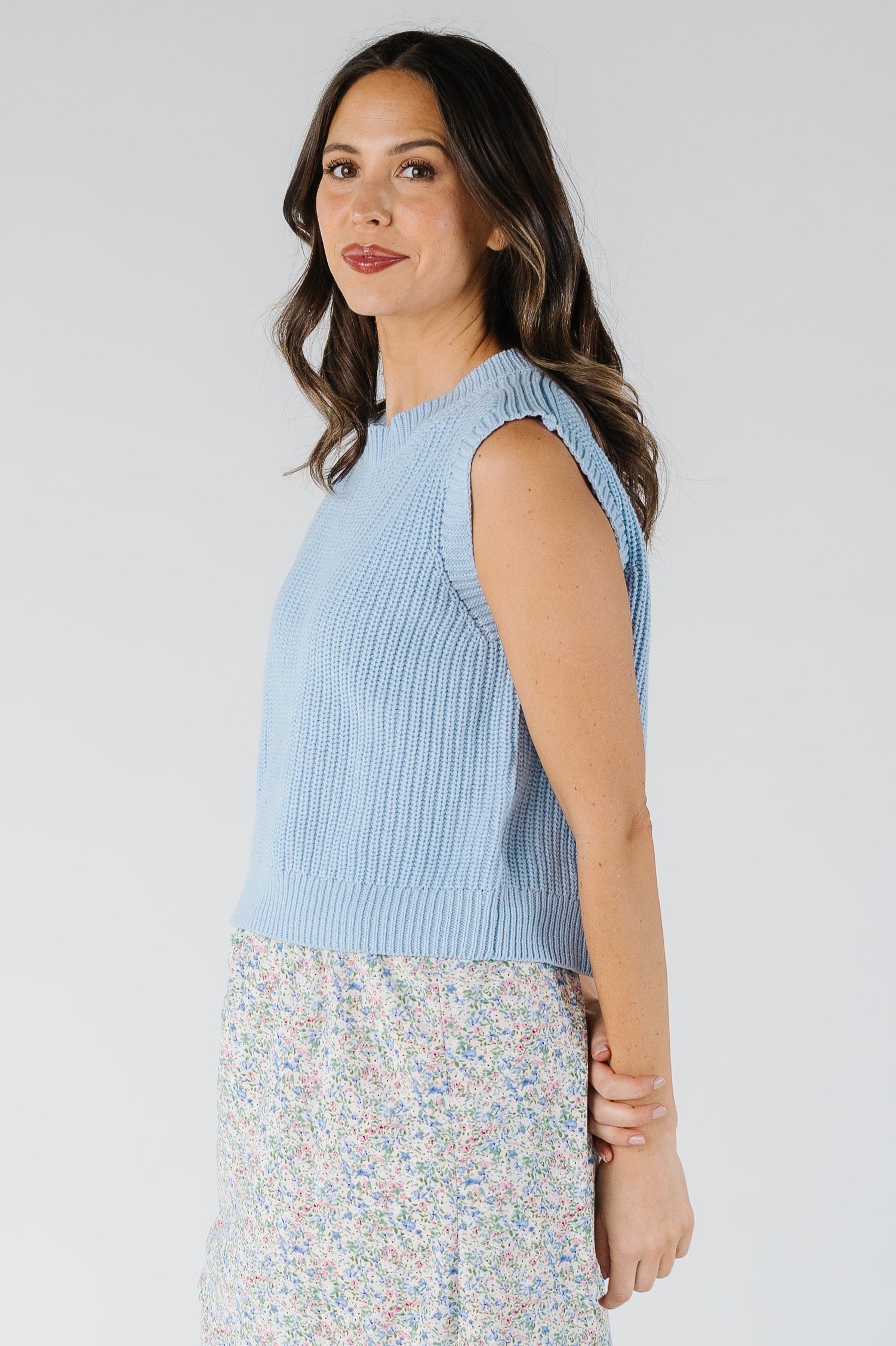 Side view of sleeveless light blue sweater vest