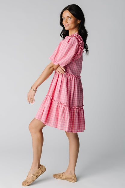 Side view of pink gingham knee length dress with half length sleeves