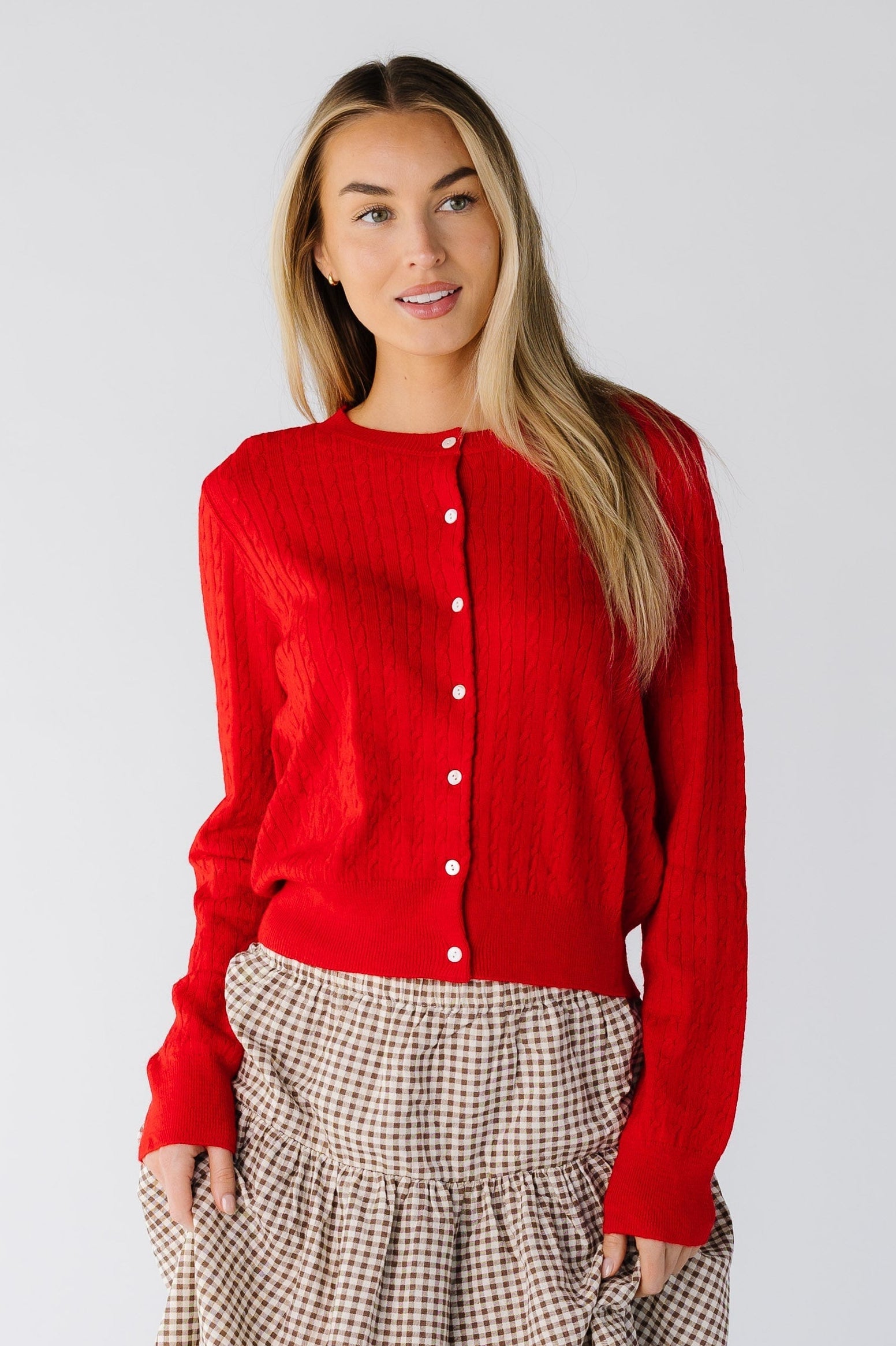 Woman wearing a long sleeve cardigan in red with a round neckline