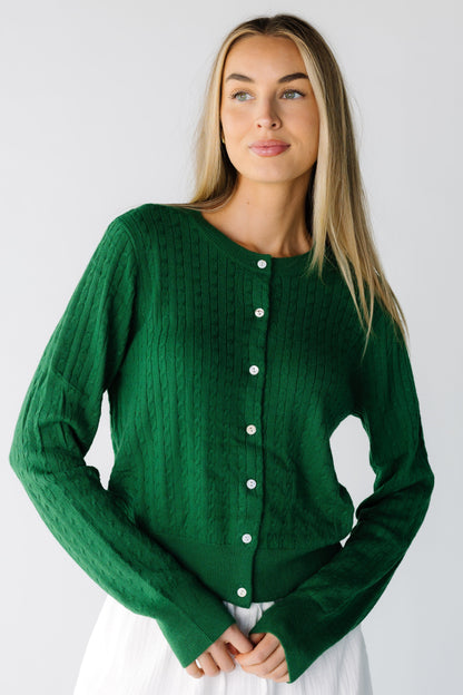Woman wearing a green cable knit cardigan with long sleeve and round neckline