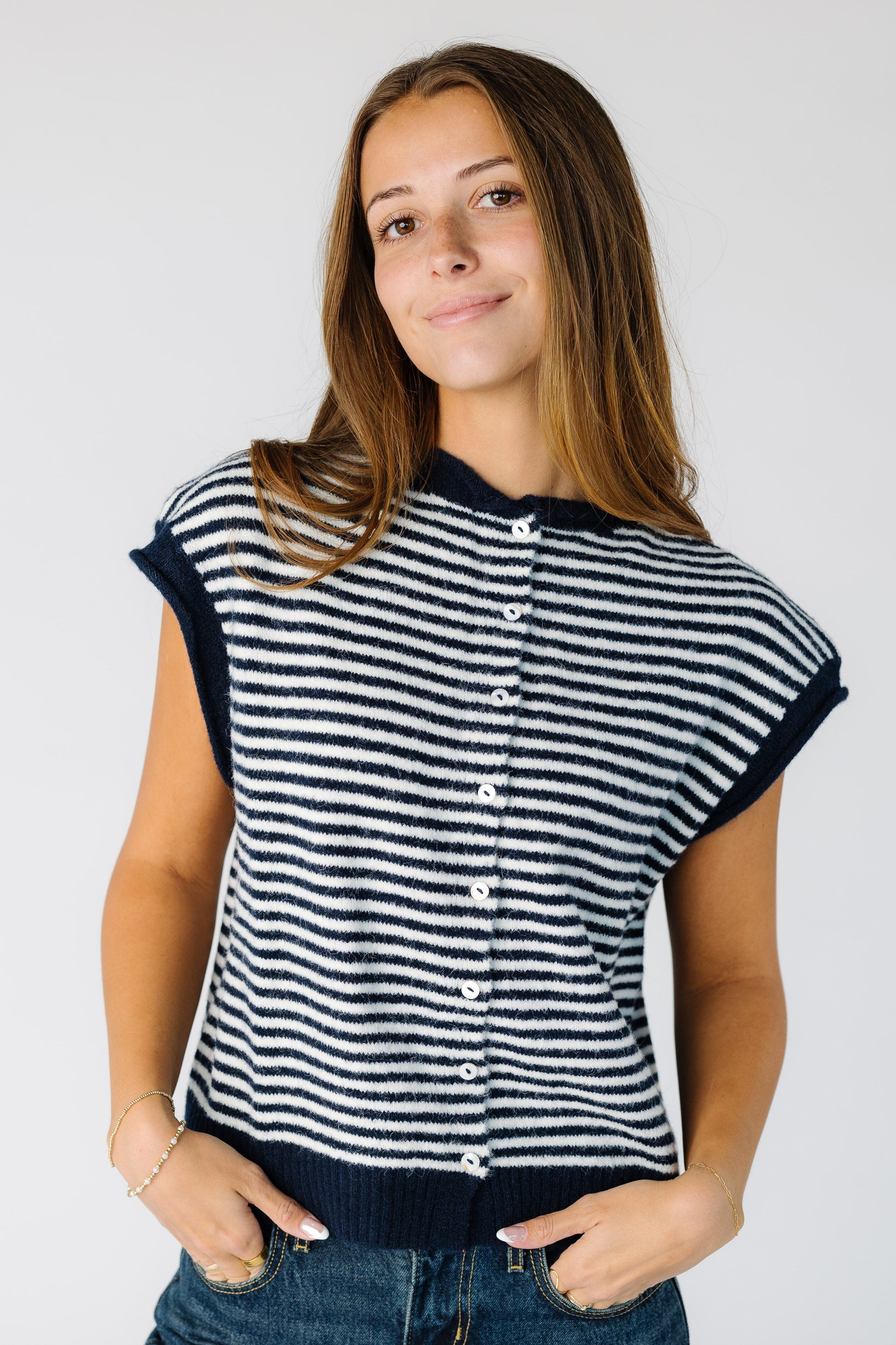 Modest stripe button down sweater vest with rolled collar and hems in navy and white.
