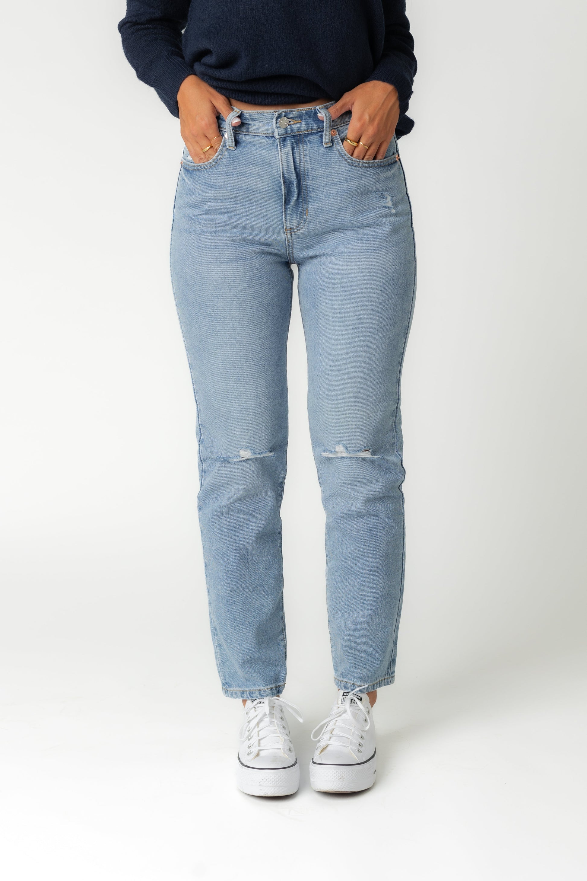 Front view of distressed high rise medium denim jeans