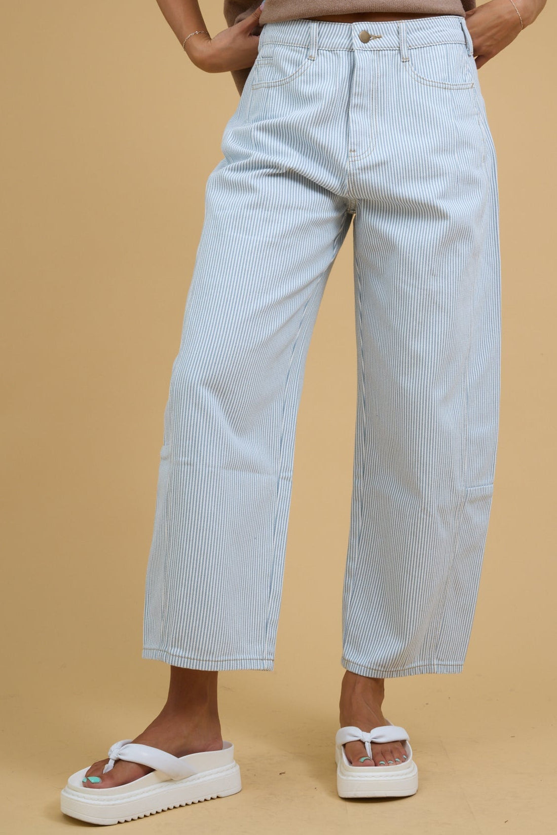Teenage girl wearing wide leg barrel jeans in white & blue stripe with side panels.