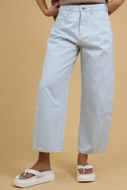 Teenage girl wearing wide leg barrel jeans in white & blue stripe with side panels.