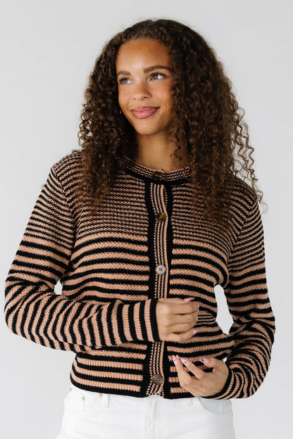 Teen girl wearing a modest taupe and black horizontal stripe cardigan with long sleeves and a round neckline.