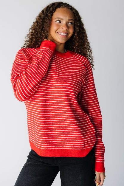 Woman wearing a modest red pullover with narrow white stripe and exposed seams