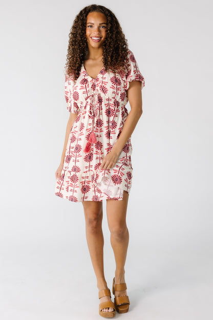 Teenage girl wearing a cream mini dress with pink and mauve floral print