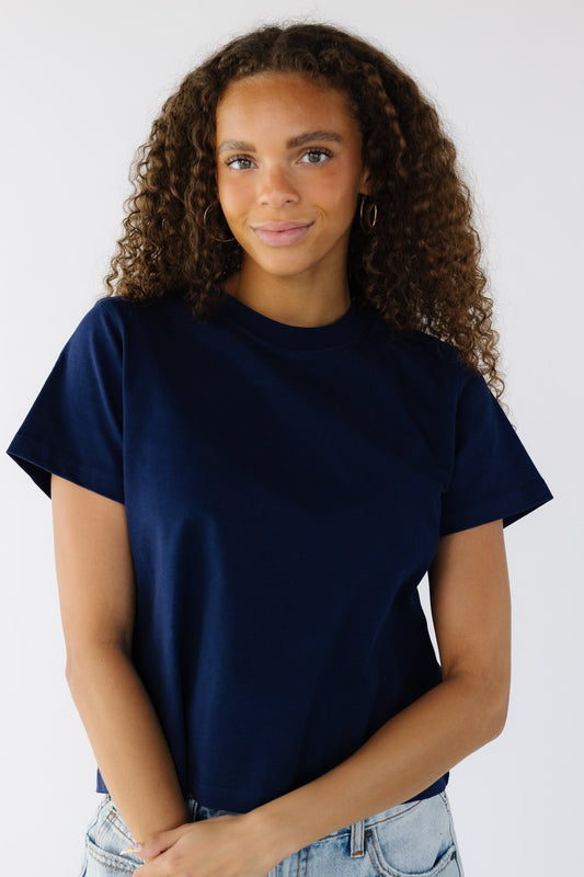 Teen girl wearing a navy short sleeve tee with a crew neckline.