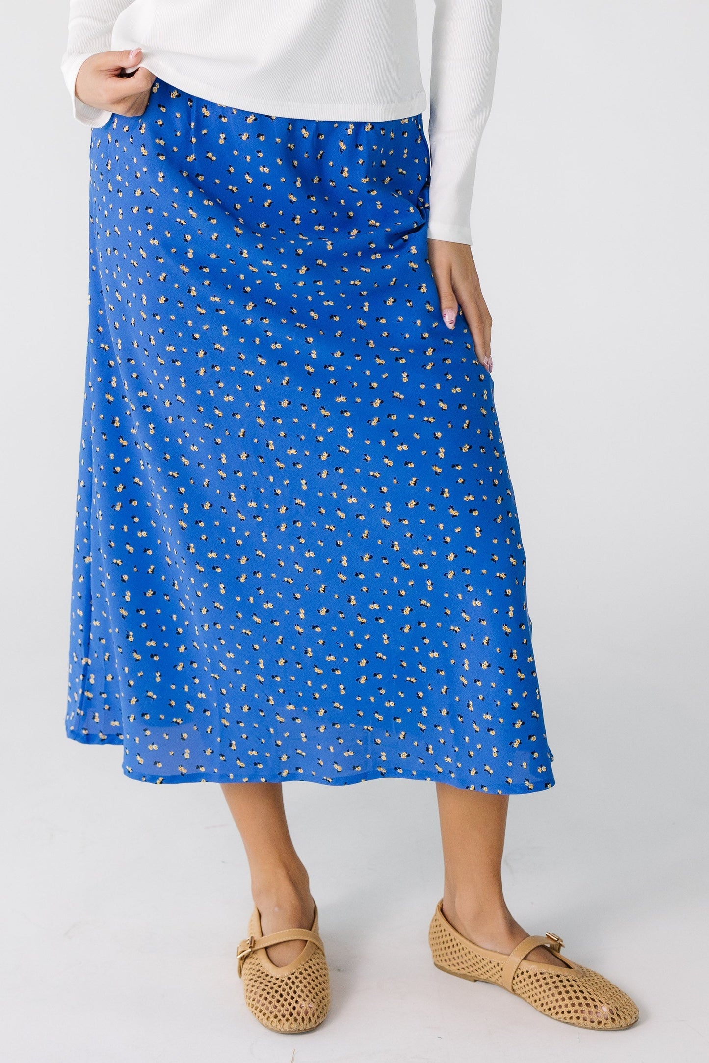 Teen girl wearing a blue floral midi skirt.