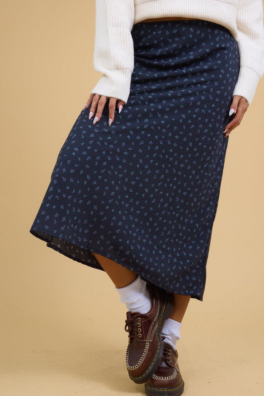 Young woman wearing an A-line modest blue floral midi skirt.