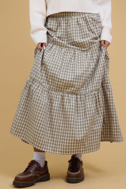 Teenage girl wearing a modest stone plaid, tiered midi-maxi skirt.
