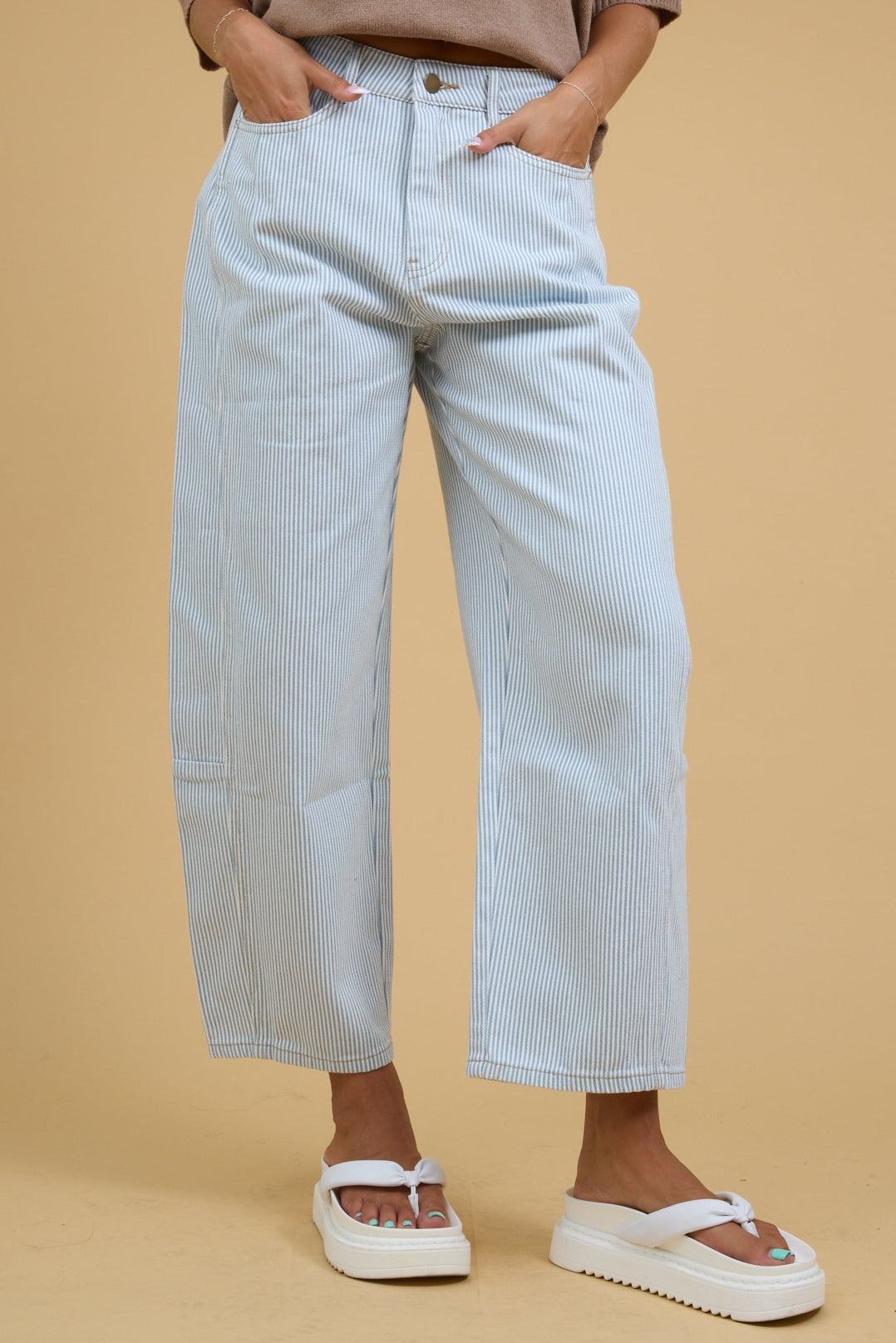 Young woman wearing modest white & blue wide leg barrel pants with a button and zipper closure.