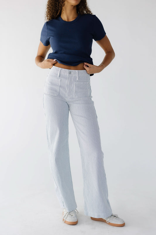 Young woman wearing a white & navy stripe jeans with a high rise waist, front patch pockets and a wide cut leg.