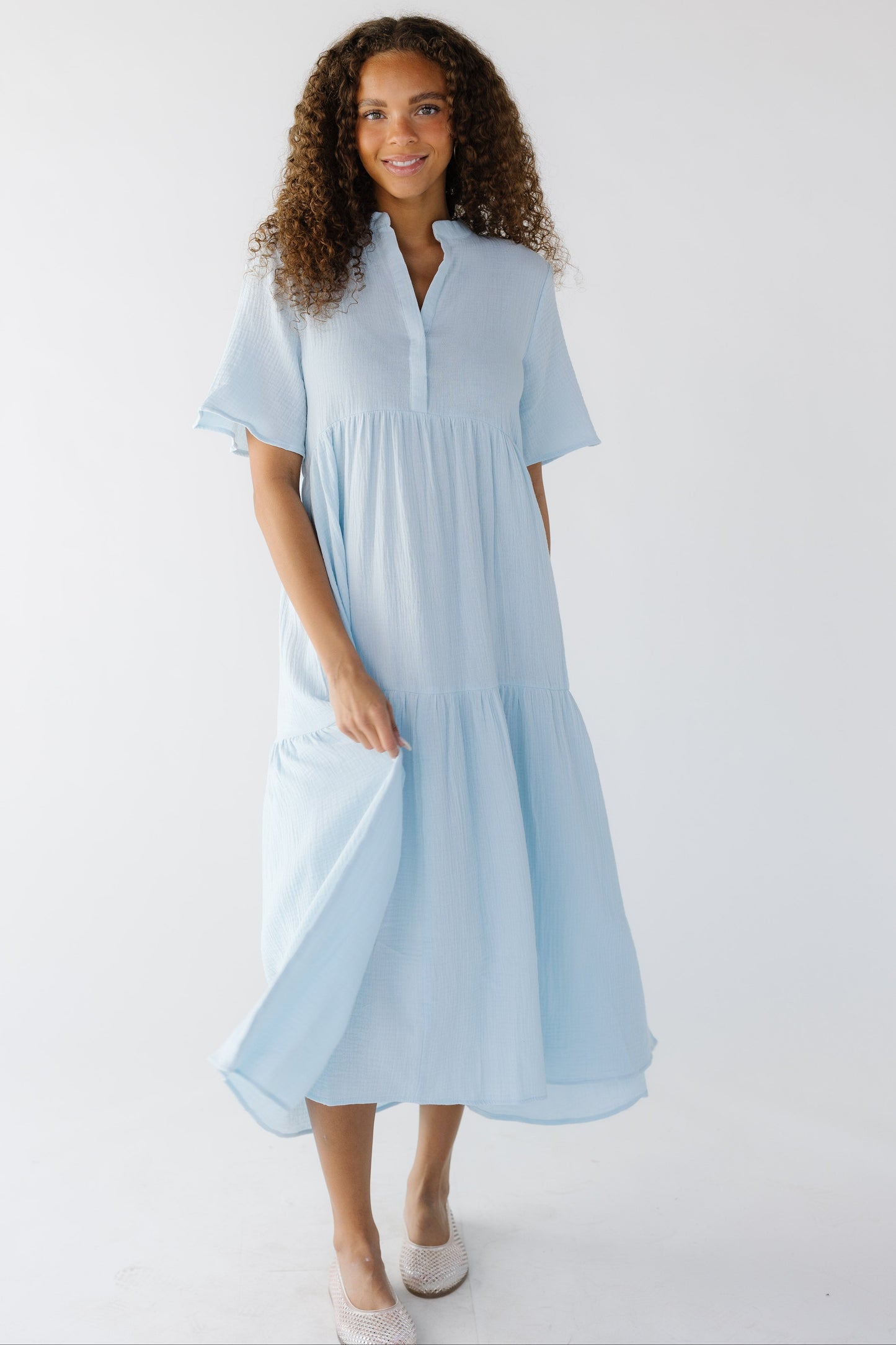 Teenage girl wearing a modest light blue midi dress with short sleeves, V-neckline.