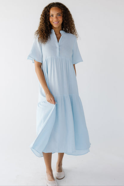 Teenage girl wearing a modest light blue midi dress with short sleeves, V-neckline.