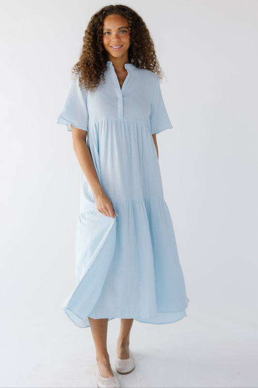 Teenage girl wearing a modest light blue midi dress with short sleeves, V-neckline.
