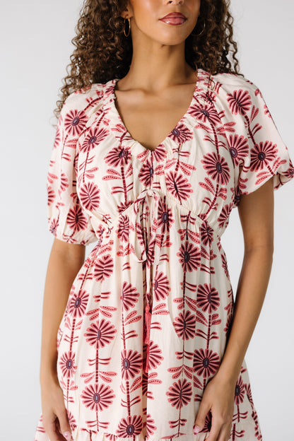 Close body view of a teenage girl in a cream mini dress with a V-neckline and short sleeves.