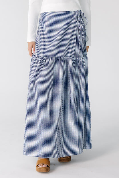 Teenage girl wearing a navy gingham wrap maxi skirt, with a drop waist.
