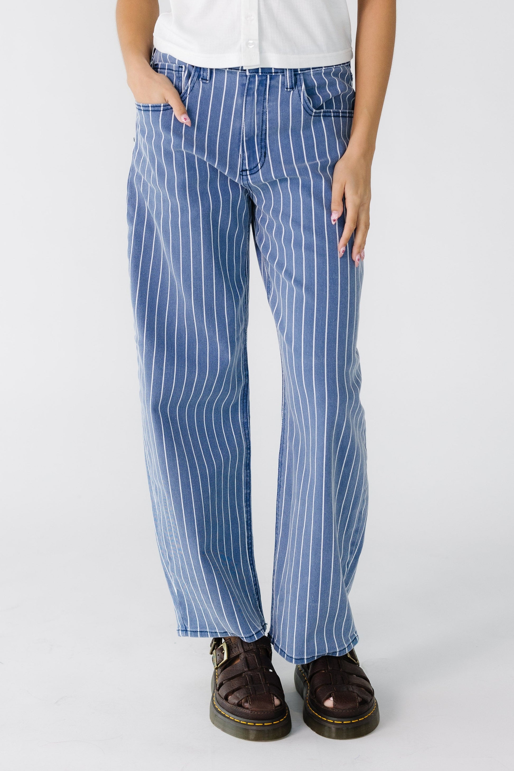 Teen girl wearing a modest pair of wide cut barrel jeans in navy and white vertical stripe.