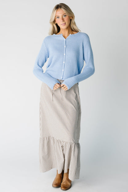 Full view of light blue cardigan with white buttons and long sleeves