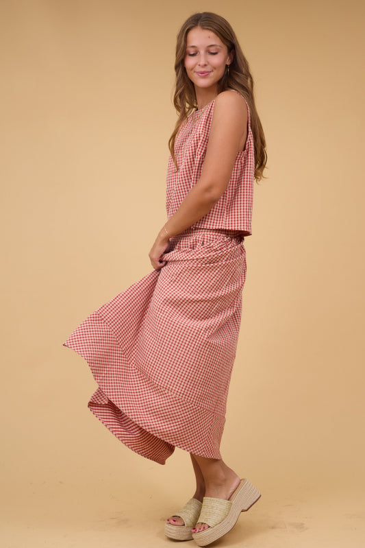 Young woman wearing a 2 piece plaid tod & skirt set with a sleeveless top and a ful skirt with front pleats.