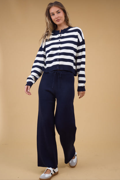 Young woman wearing a modest 2 piece sweater set with wide leg navy sweater pant and a navy & white stripe long sleeve button down top.