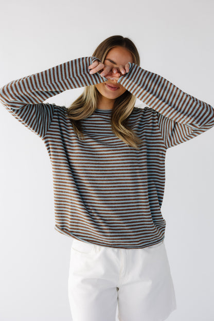 Young woman wearing a modest teal & brown stripe lightweight sweater top with long sleeves and a round neckline.