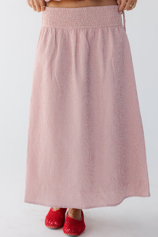 Young woman wearing a modest pink gingham midi-maxi skirt with a wide smocked waistband.
