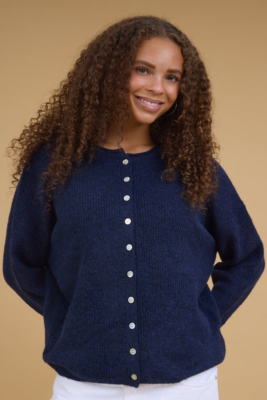 Teenage girl wearing a modest soft navy button down cardigan with long sleeves.