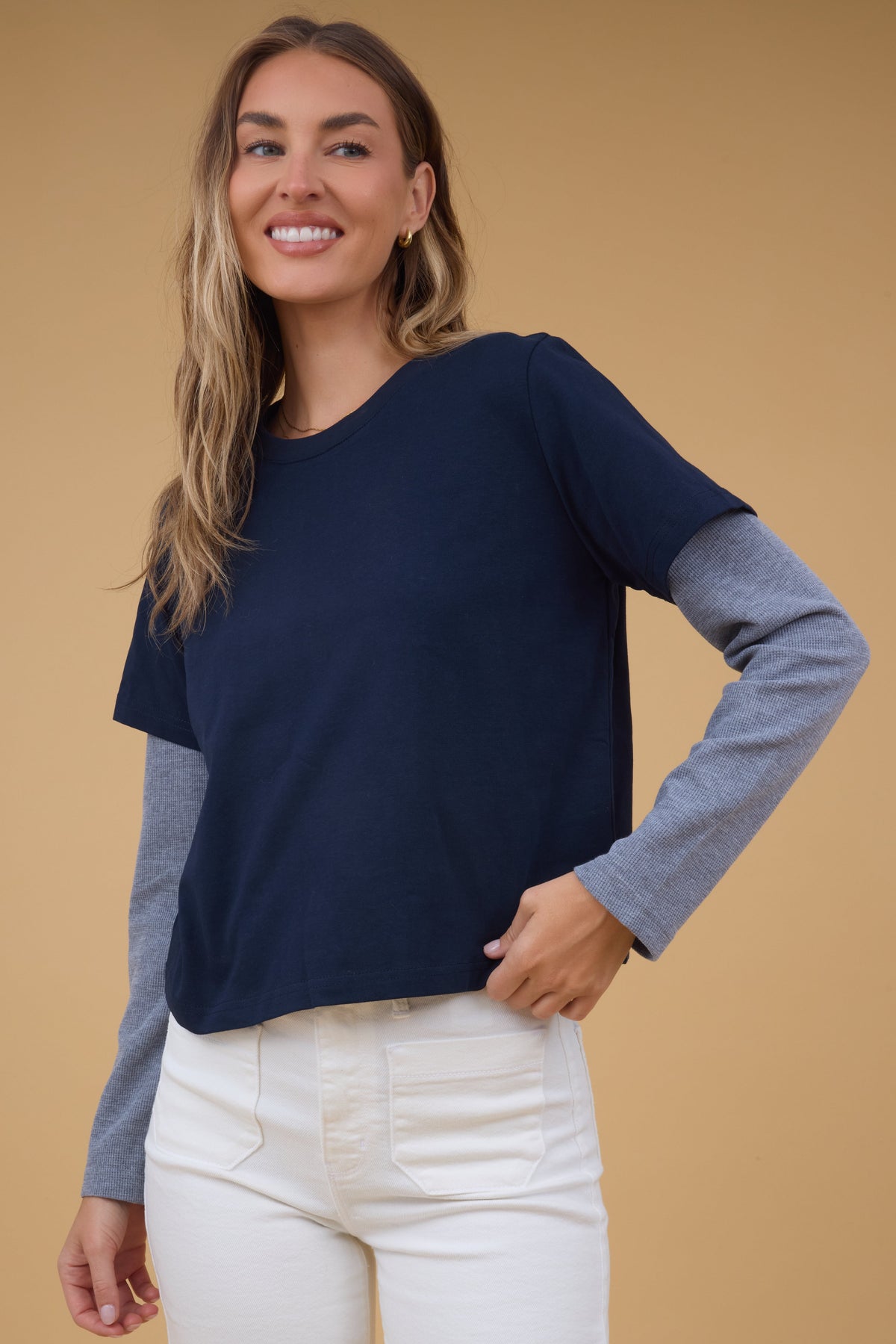 Young woman wearing a modest navy short sleeve tee with waffle weave long sleeves.