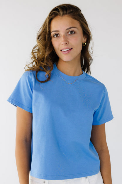 Woman wearing a  bright blue short sleeve tee with a crew neckline.