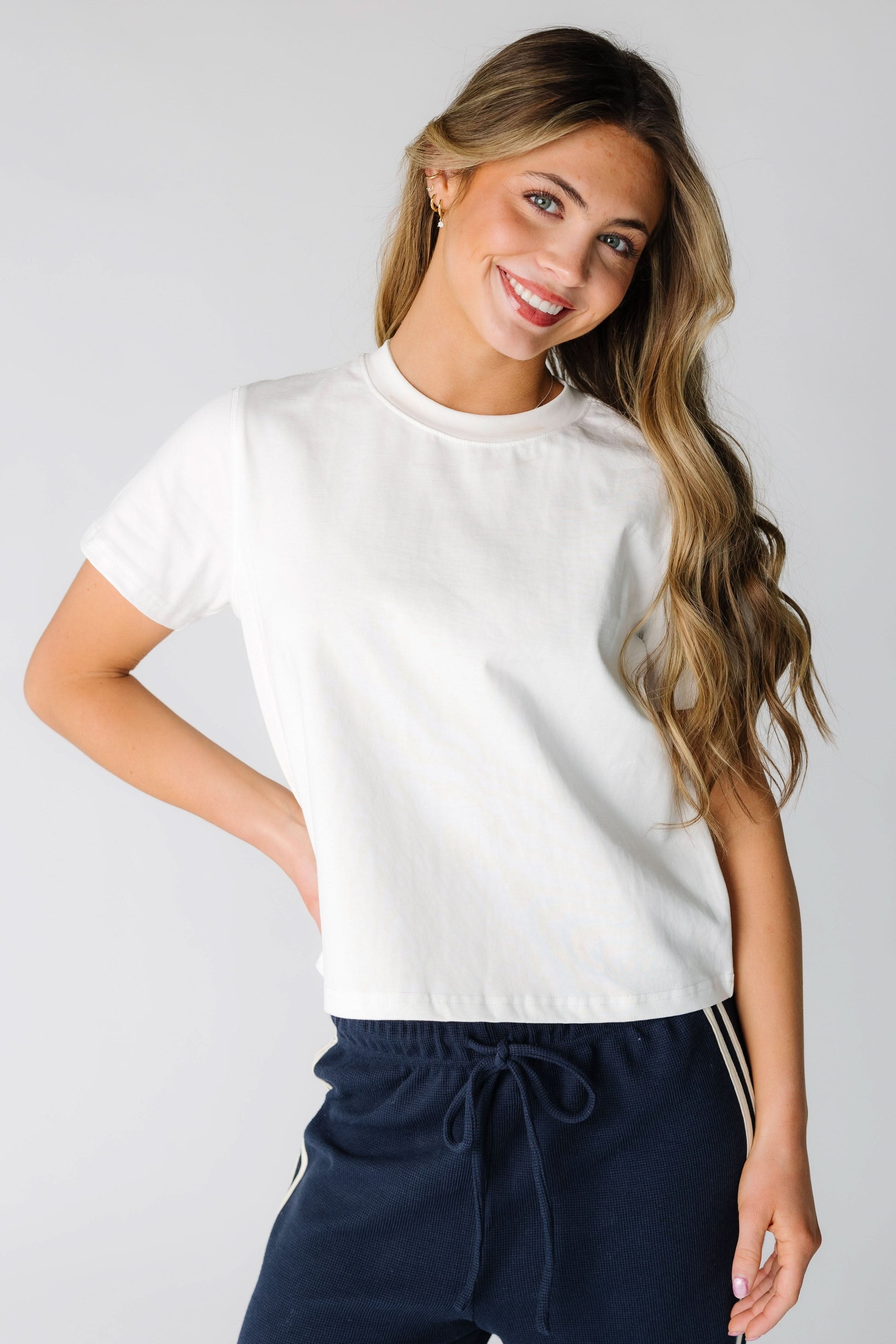Young woman wearing a modest white tee with a crew neckline and short sleeves.
