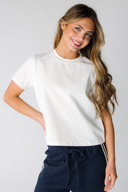 Young woman wearing a modest white tee with a crew neckline and short sleeves.