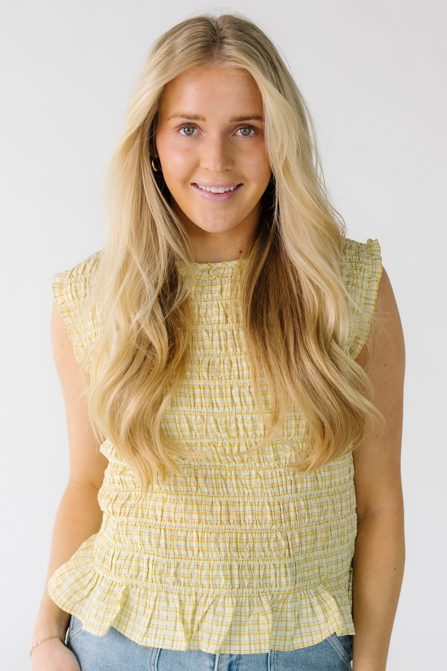 Woman wearing a modest yellow smocked bodice top with a round neckline.
