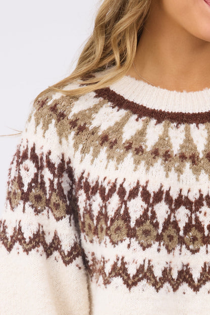 A close up view of a woman wearing a cream sweater with a brown & beige nordic sweater for women & teen girls.