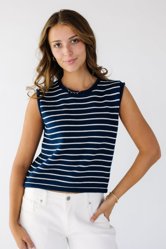 Young woman wearing a modest navy and white stripe sleeveless sweater vest with a crew neckline.