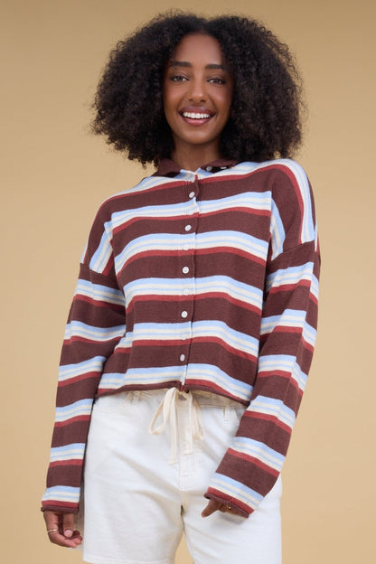 Young woman wearing a brown & blue multicolor stripe cardigan with long sleeves.