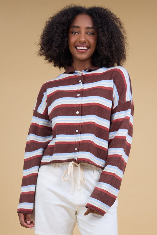 Young woman wearing a brown & blue multicolor stripe cardigan with long sleeves.