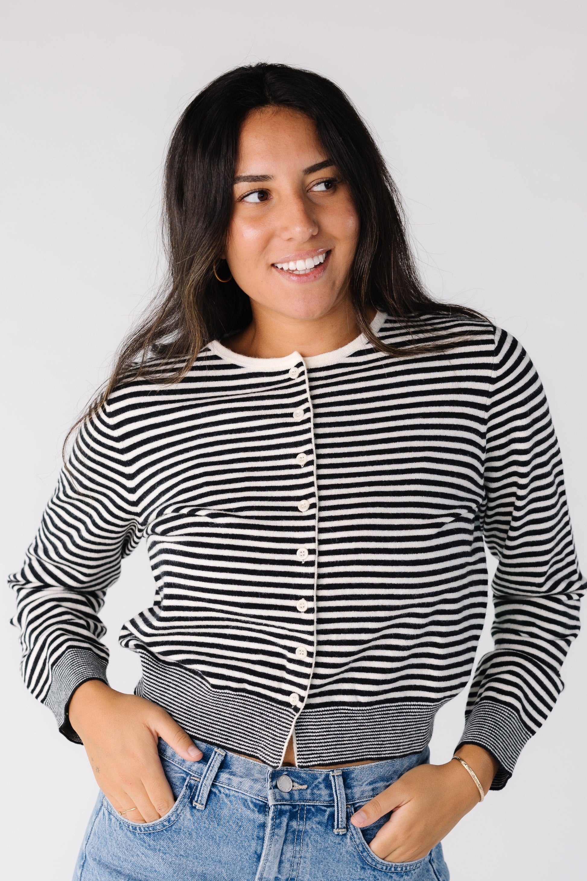 Woman wearing a black and white stripe cardigan with white buttons