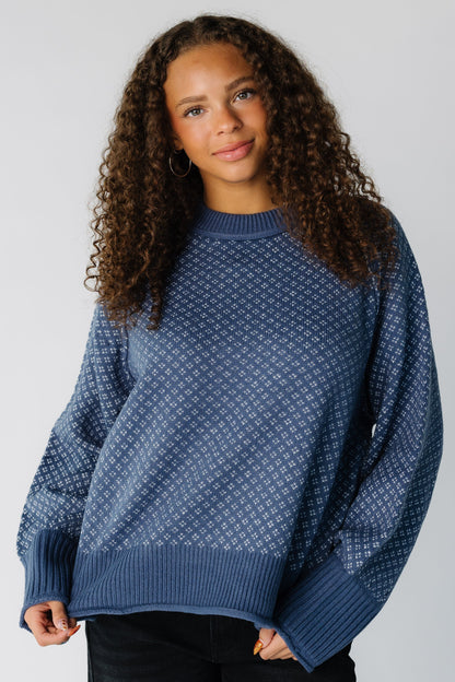 Teen girl wearing a blue & white patterned pullover sweater with long sleeves 