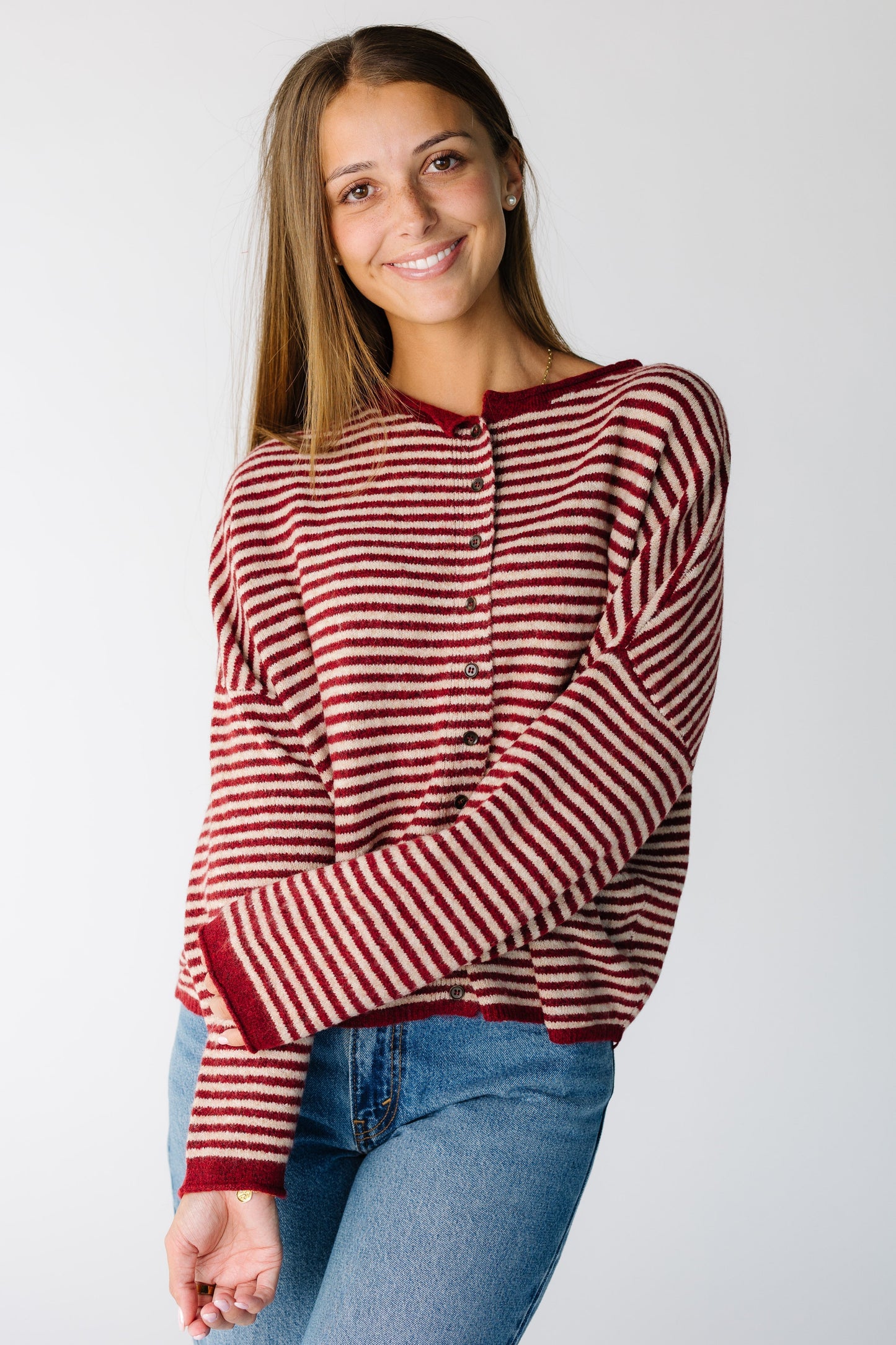 Woman wearing a red and cream stripe cardigan with long sleeves