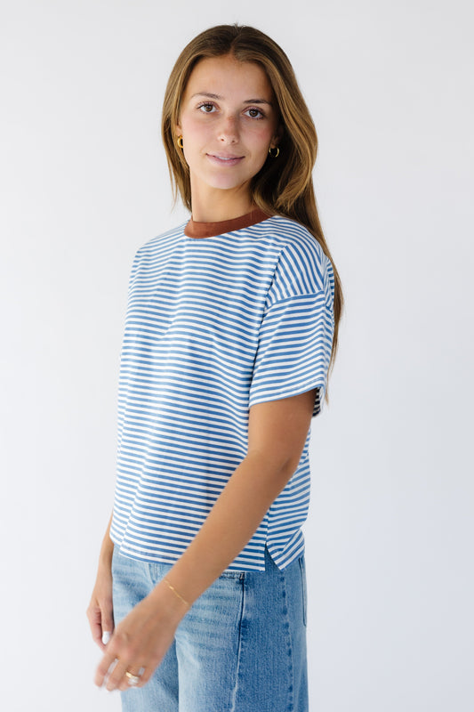 Young woman wearing a modest blue & white stripe tee with a contrasting neckline and short sleeve.