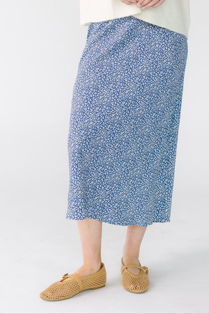 Young woman wearing a navy A-line midi skirt.
