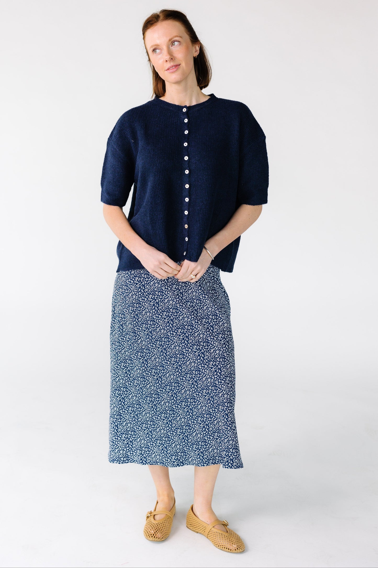 Woman wearing a modest A-line midi skirt in navy and white.