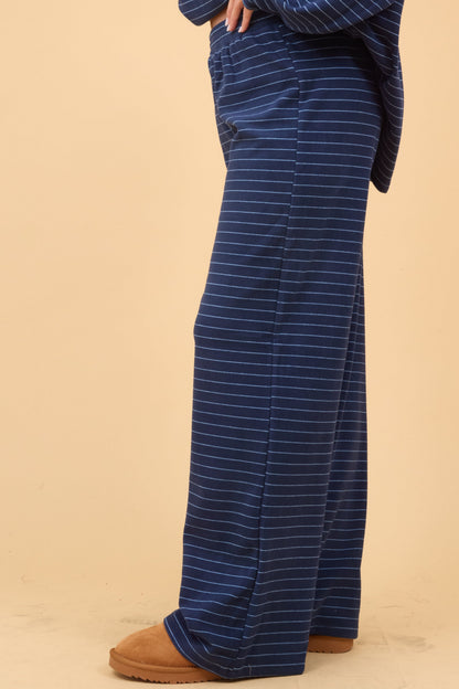 Side view of a woman wearing a navy stripe, wide cut lounge pant.